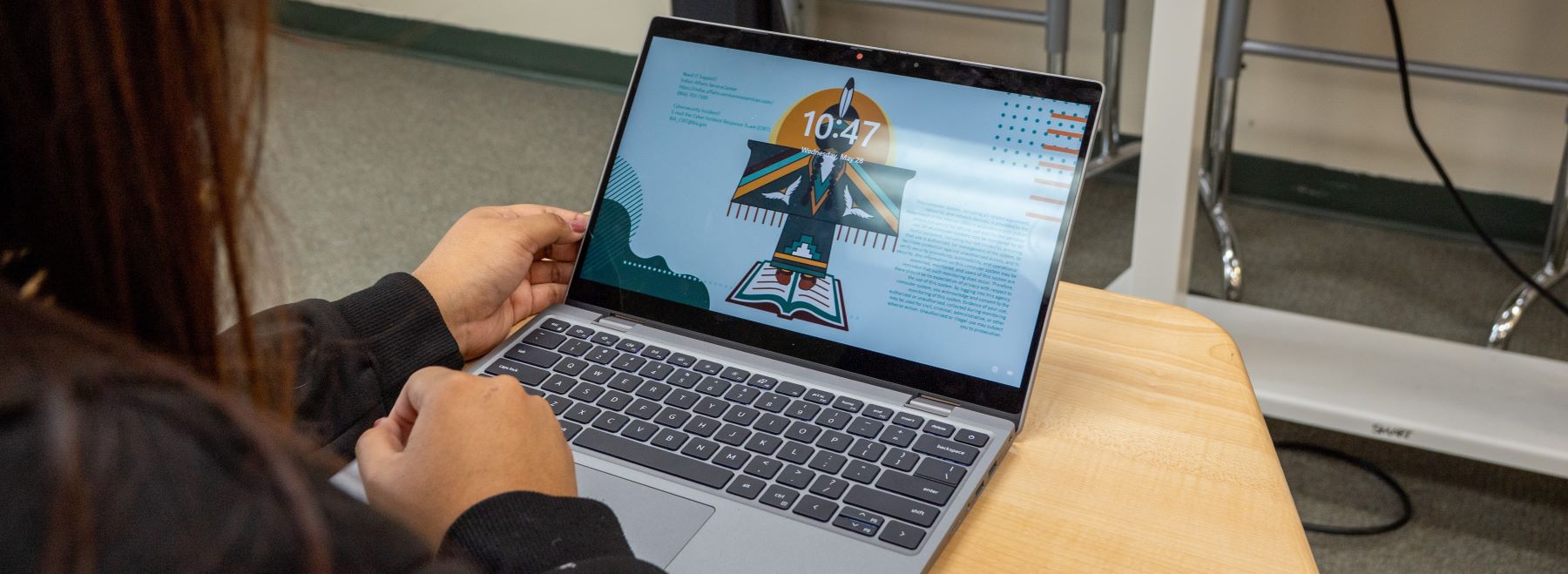 Student sitting at their desk focusing on the laptop screen.
