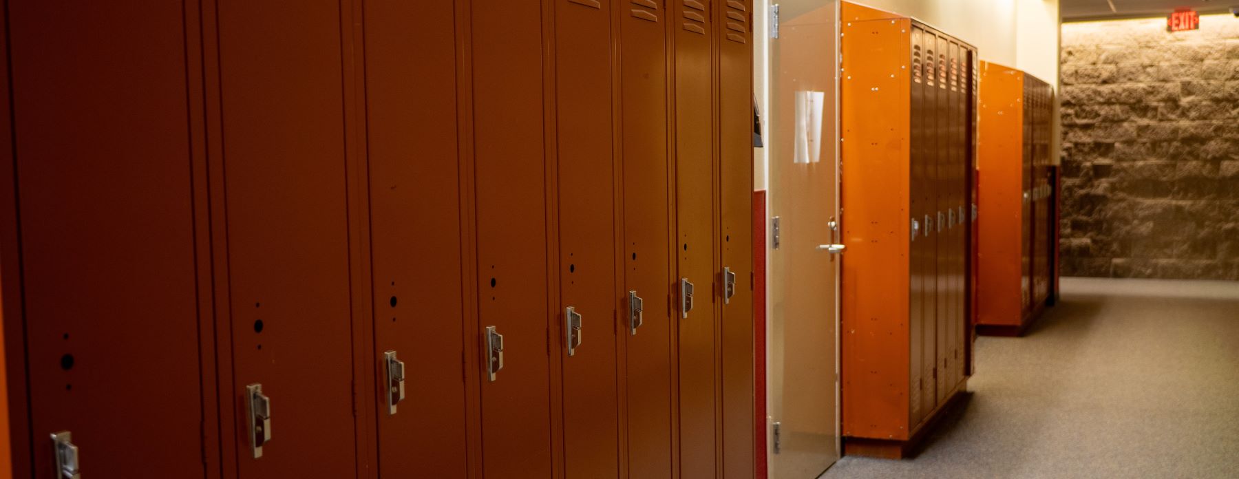 A row of colorful lockers lined up in a school hallway, with bright walls and a polished floor.