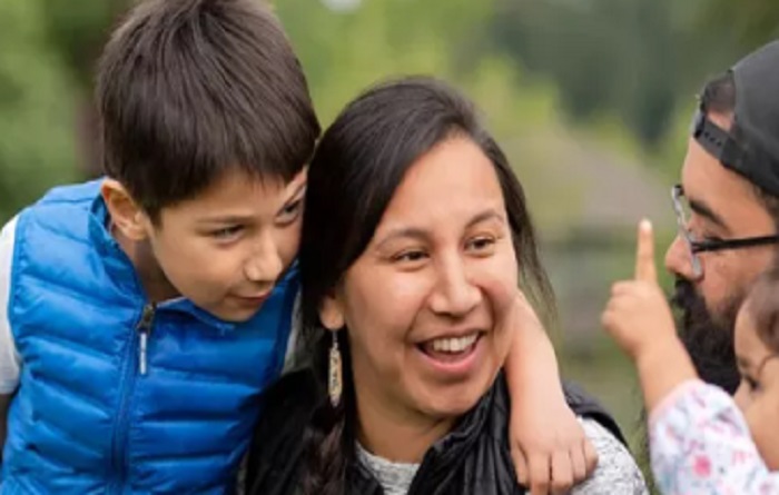 Smiling mother and son looking at daughter and father. 